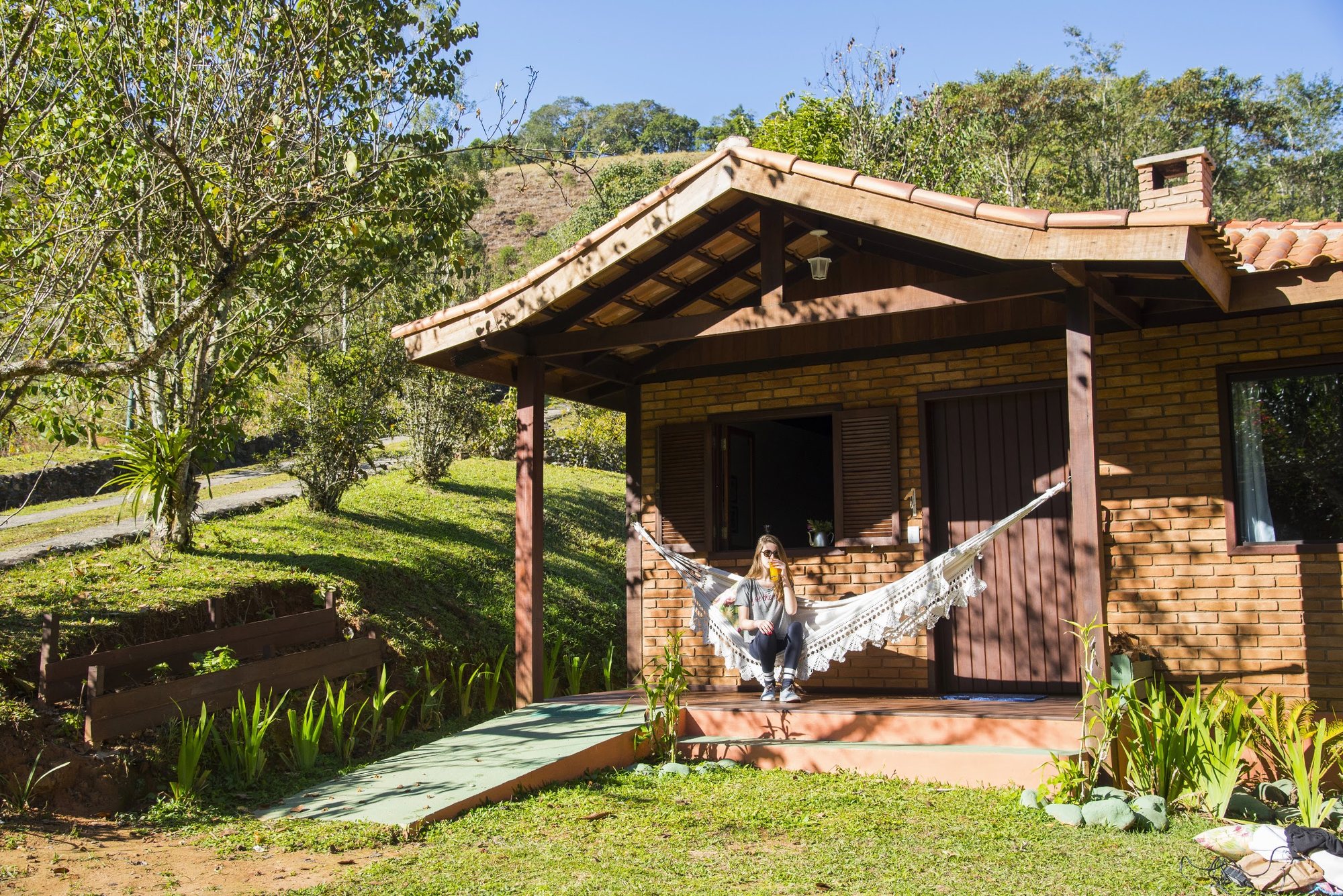 Fachada do Estúdio Pássaros com rede na varanda e gramado