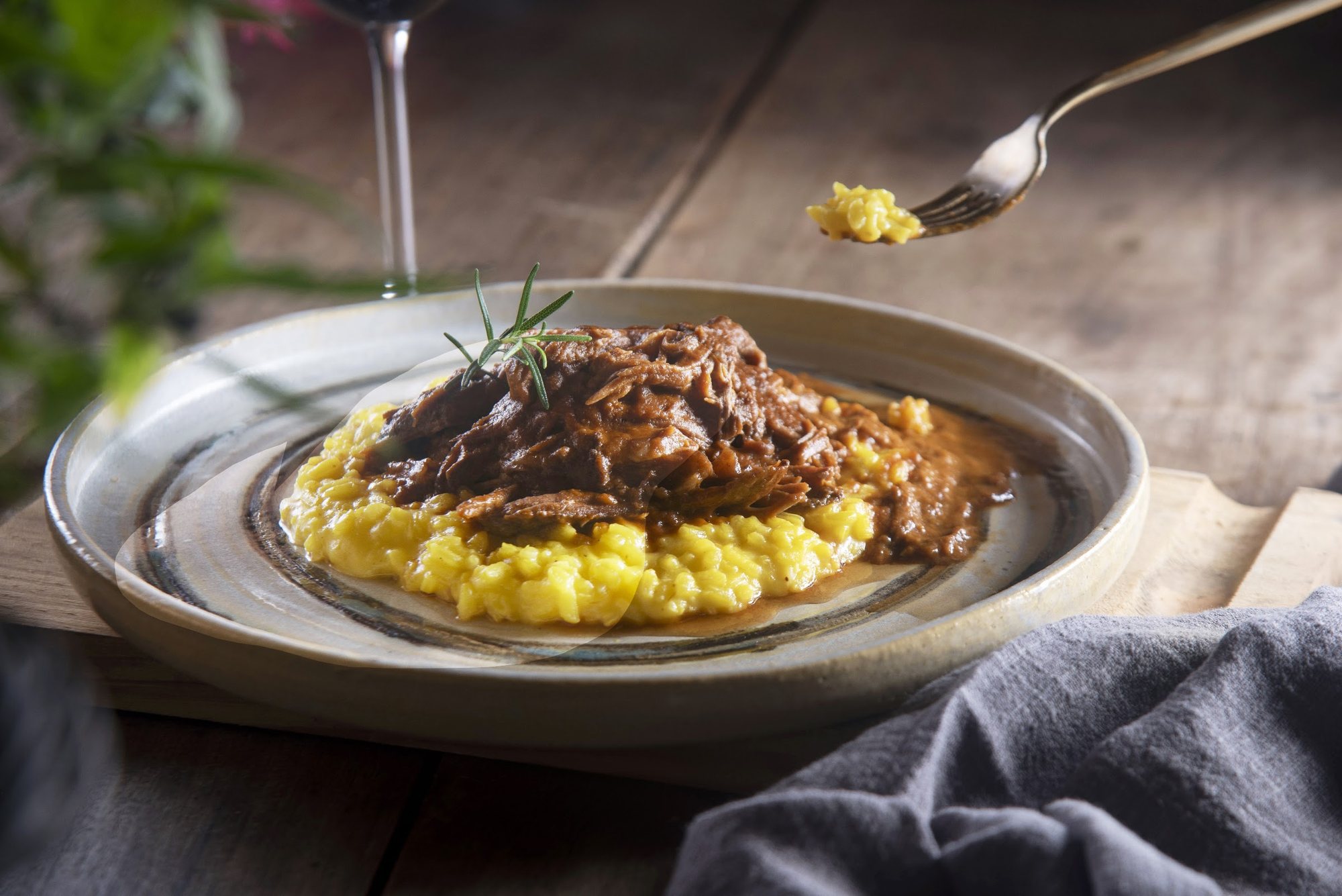 Prato de ragu servido sobre polenta cremosa