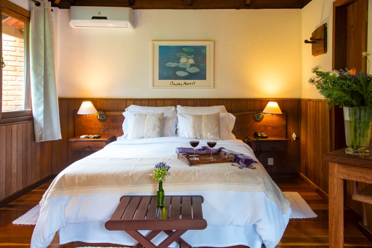 Cama de casal da Suíte Monet com bandeja e taças